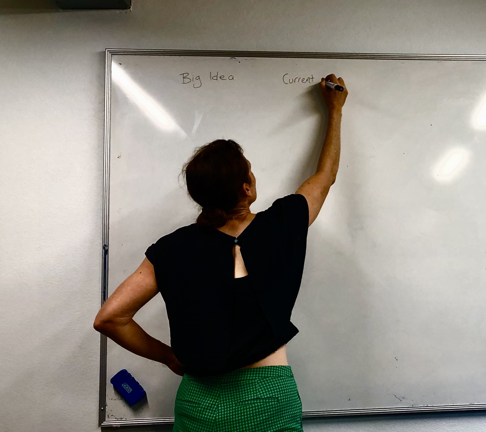Tamara writing down 'Big Ideas' on a blackboard as she talks to the astro team